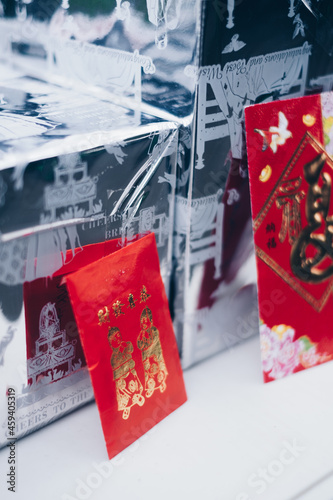 Poortrait orientation of red envelopes or red packets called Ang Pao or Ang Pow, also Hongbao or Hungbao in Mandarin and Lai See in Cantonese on white table. Selective focus. 