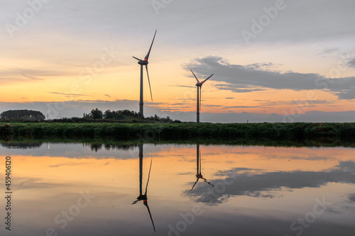 Wind Turbines at sunset besides a River