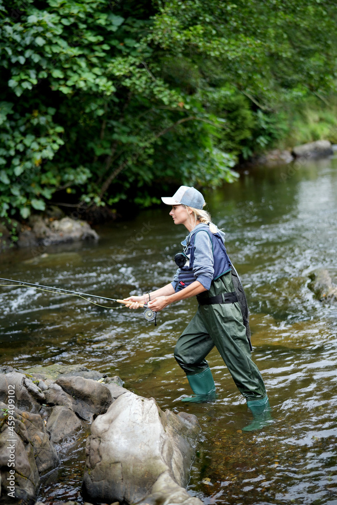 young woman fly fishing in a mountain river young woman fly fishing in a mountain river