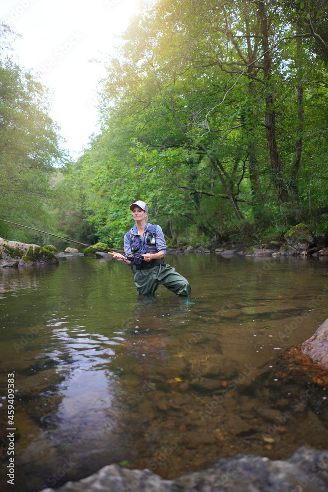 young woman fly fishing in a mountain river young woman fly fishing in a mountain river