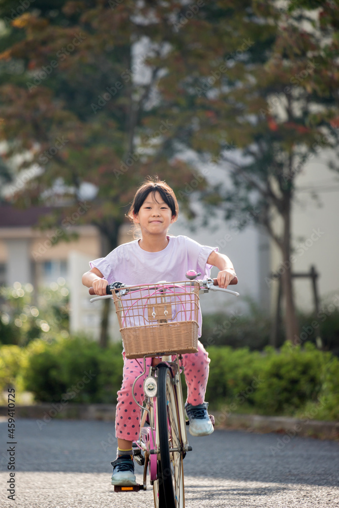 Obraz premium 真夏の公園で自転車を乗って遊んでいる子供の姿