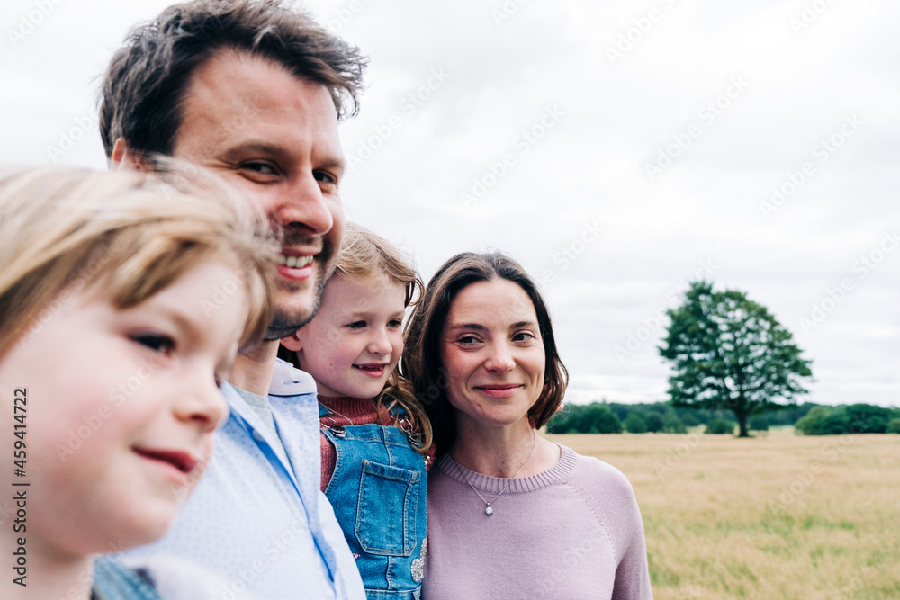 Smiling parents and daughters at meadow Smiling parents and daughters at meadow