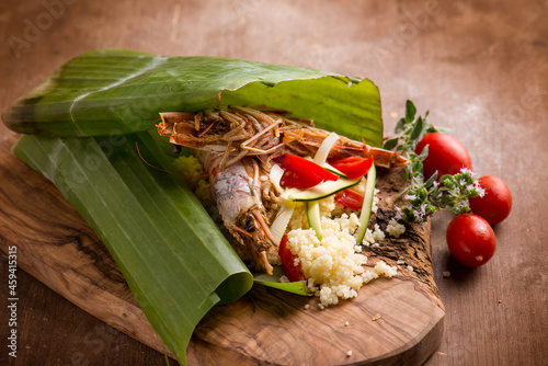 shrimp coucous with zucchinis cooked on banana leaf photo