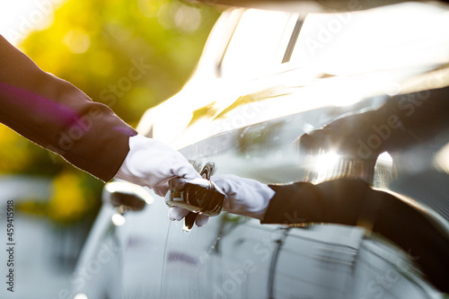 Closeup of Chauffeur opening car door with glove