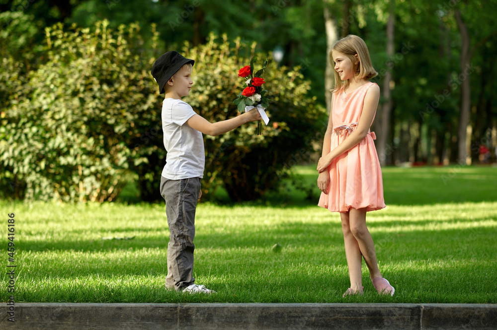 Obraz premium Children's date, boy gives flowers to girl
