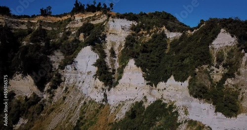 Summer aerial of dramatic clay cliffs and blue sky - Mangaweka, New Zealand photo