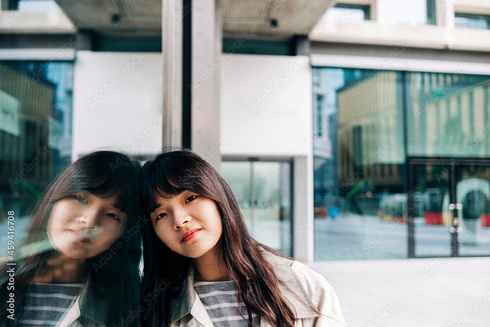 Woman with long hair leaning on glass wall Woman with long hair leaning on glass wall
