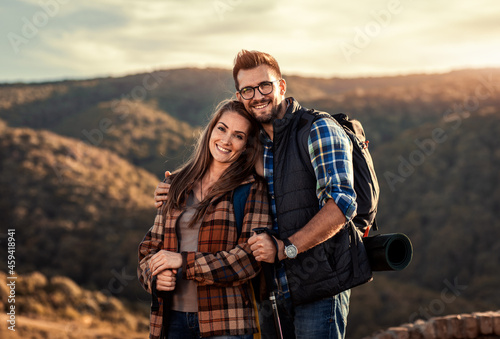 Portrait of adult couple hiking in nature at sunset.