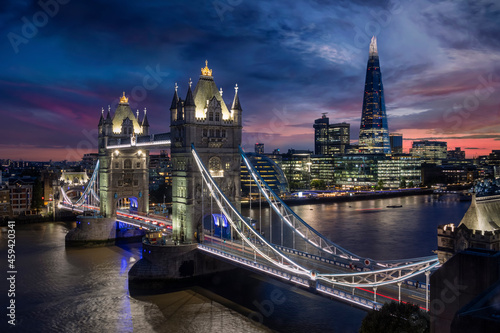 Elevated view to the illuminated Tower Bridge and urban skyline of London along the river Thames, UK, just after sunset