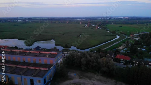 Aerial View Of Green Field And Marsh Behind Mercon Kloos Building At The Noord Riverbank In Alblasserdam, Netherlands At Sunset. photo