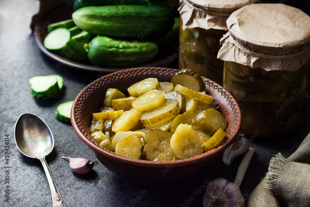 Pickled cucumber salad in a bowl and jars Pickled cucumber salad in a bowl and jars