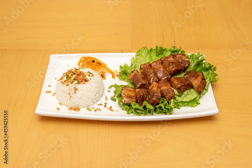Filipino recipe for fried kawali suckling pig with sauce and garnish of white rice with pickled vegetables photo