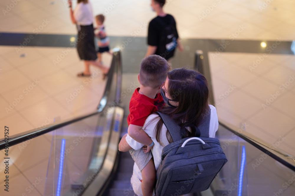 Mom with a child in her arms, descend on an escalator