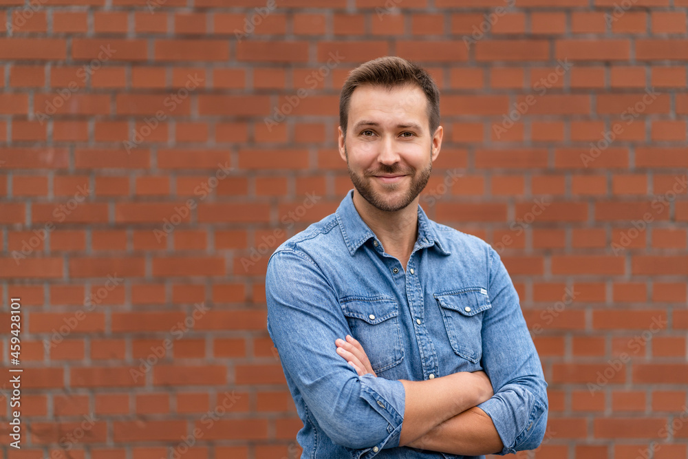 Happy businessman with arms crossed in front of wall Happy businessman with arms crossed in front of wall