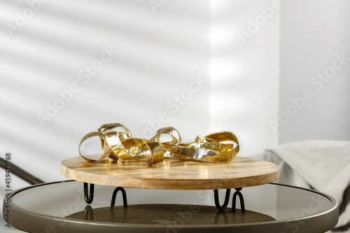 Glass round table with Christmas products against a white interior on a beautiful sunny day 