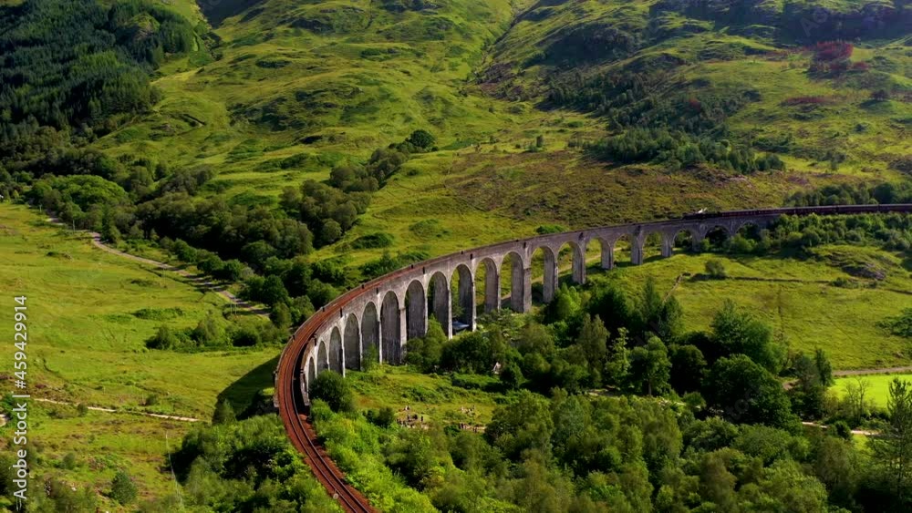 Stockvideon Rotating drone shot of famous railroad bridge in the Glenfinnan Viaduct with train