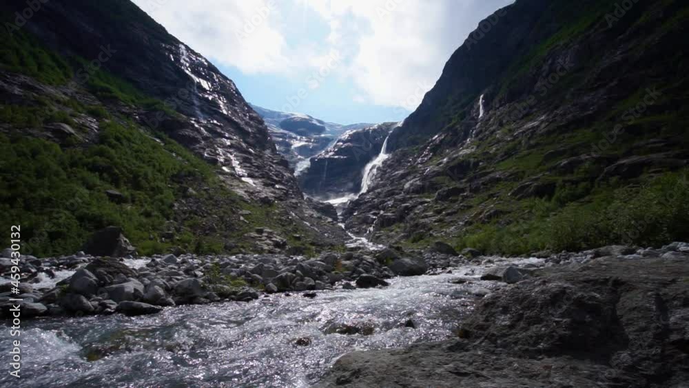 Steady shot of a Norwegian glacier river, melting ice builds rivers and Waterfalls. Glacier in the background Steady shot of a Norwegian glacier river, melting ice builds rivers and Waterfalls. Glacier in the background
