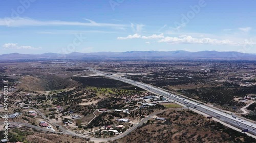 An aerial 4K shot of cars traveling on highway roads near the green field in Victorville, California photo