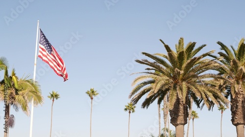 Palms and american flag, Los Angeles, California USA. Summertime aesthetic of Santa Monica Venice Beach. Star-Spangled Banner, Stars and Stripes. Atmosphere of patriotism in Hollywood. LA vibes.