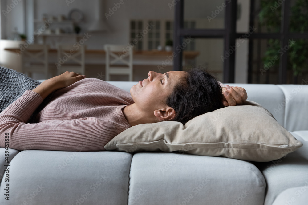 Tired calm millennial Caucasian woman lying relaxing on couch at home sleep or take nap. Exhausted asleep young female renter rest on comfortable sofa furniture daydream on pillow. Fatigue concept. Tired calm millennial Caucasian woman lying relaxing on couch at home sleep or take nap. Exhausted asleep young female renter rest on comfortable sofa furniture daydream on pillow. Fatigue concept.