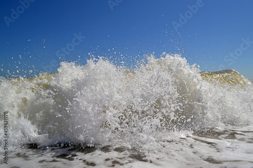 Sea foam surf crushing on the shore in sunny day