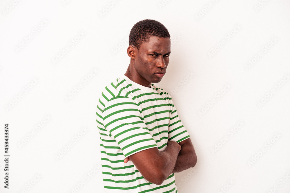 Fototapeta premium Young African American man isolated on white background frowning face in displeasure, keeps arms folded.