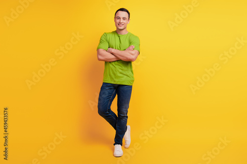 Portrait of successful guy folded arms cool posing on yellow background © Tetiana