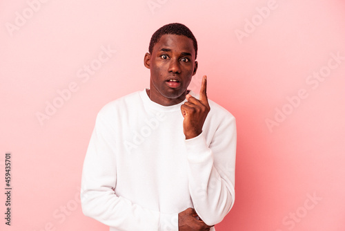 Young African American man isolated on pink background having some great idea, concept of creativity.