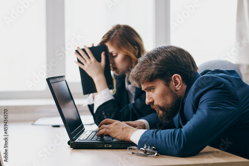 colleagues in the office in front of a laptop career work officials