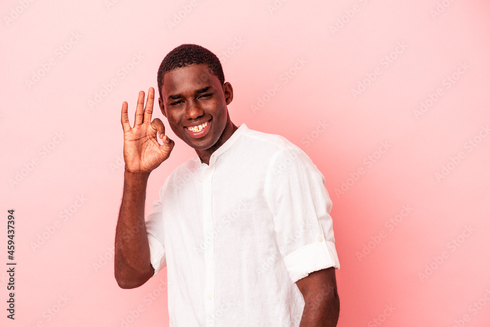 Fototapeta premium Young African American man isolated on pink background cheerful and confident showing ok gesture.