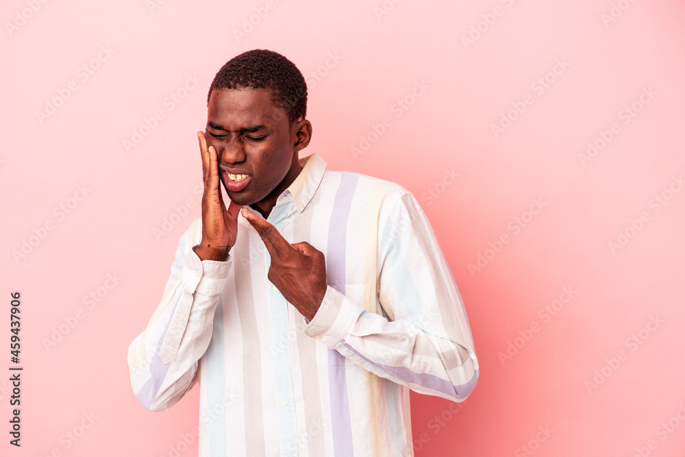 Young African American man isolated on pink background having a strong teeth pain, molar ache. Young African American man isolated on pink background having a strong teeth pain, molar ache.