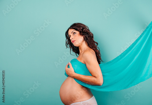 Pregnant woman expecting a child caresses her belly