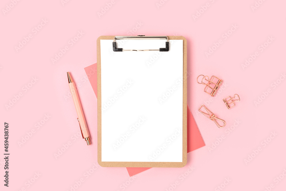 Clipboard with empty paper sheet mockup and stationery on a pink background. Workspace for study. Clipboard with empty paper sheet mockup and stationery on a pink background. Workspace for study.