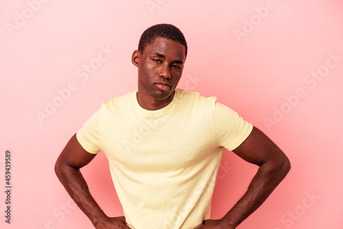 Young African American man isolated on pink background sad, serious face, feeling miserable and displeased.