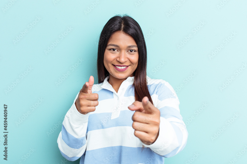 Young Venezuelan woman isolated on blue background pointing to front with fingers. Young Venezuelan woman isolated on blue background pointing to front with fingers.