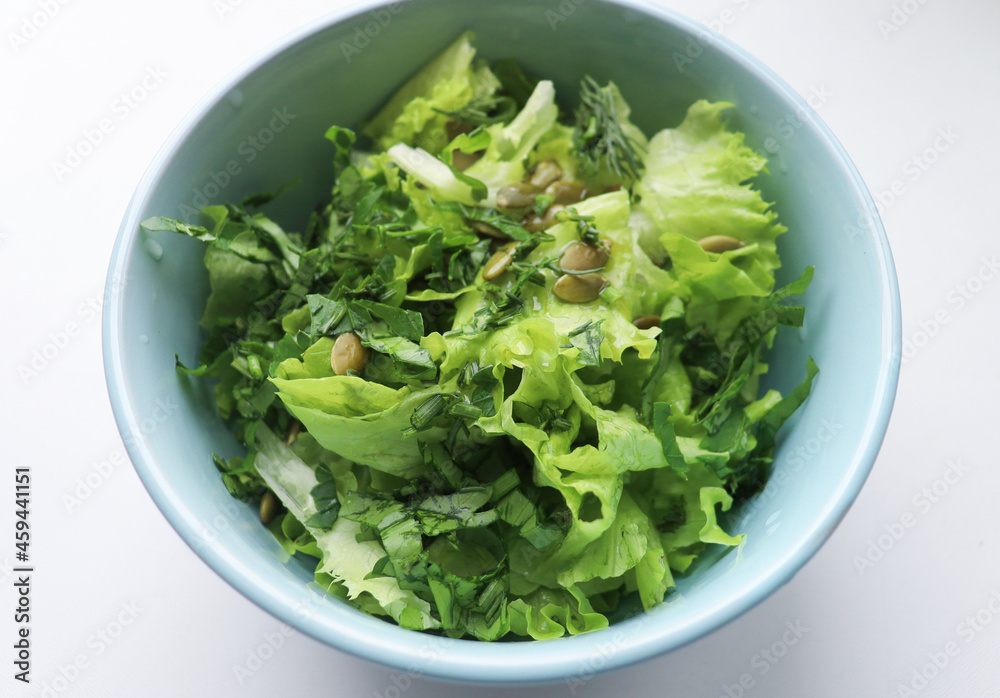 fresh salad leaves with pumpkin seeds in a plate, close-up. Comfortable digestion, proper nutrition, weight loss. The texture of vegetables, salad. Seasonal vitamins, fiber fresh salad leaves with pumpkin seeds in a plate, close-up. Comfortable digestion, proper nutrition, weight loss. The texture of vegetables, salad. Seasonal vitamins, fiber