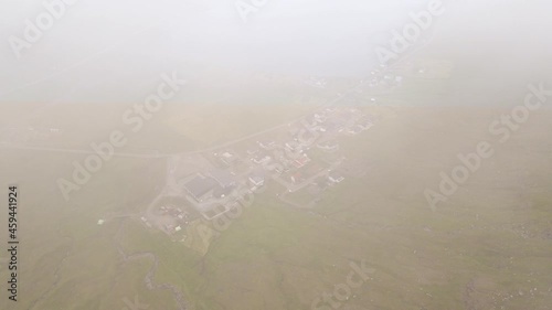Beautiful aerial view of the town of Miovagur in the Faroe Islands, with its :churchs, grass roofs and colorful Houses in front of the ocean	