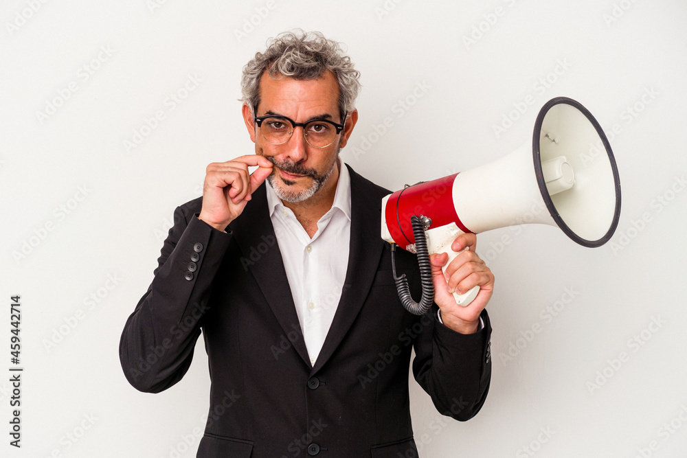 Middle age business man holding a megaphone isolated on white background with fingers on lips keeping a secret. Middle age business man holding a megaphone isolated on white background with fingers on lips keeping a secret.