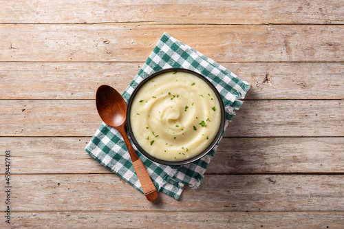 Mashed potatoes in a bowl on wooden table. Top view. Copy space