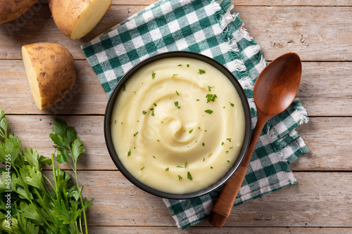 Foto Mashed potatoes in a bowl on wooden table. Top view.