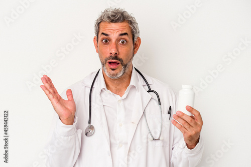 Middle age doctor caucasian man isolated on white background surprised and shocked.