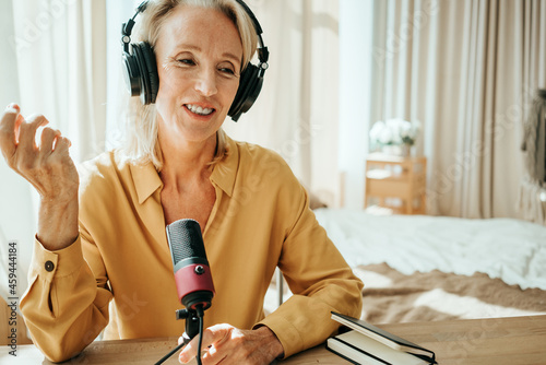 Stylish mature woman at her cozy home apartment. Straming her first audio podcast photo