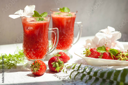 Refreshing summer drink with strawberry on light background
