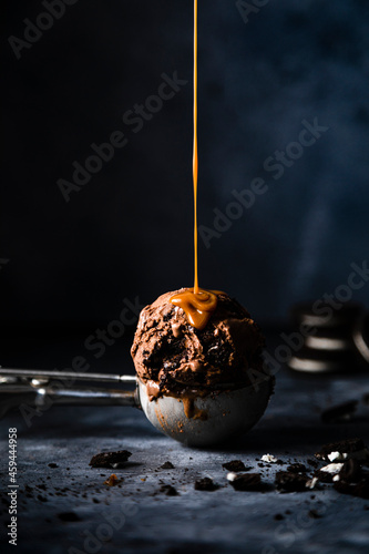 Studio shot of caramel pouring on scoop of chocolate ice cream photo