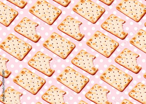 Pattern of crackers flat laid against pink polka dot background