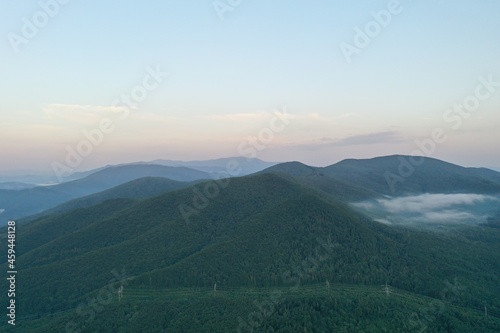 Peaks of the Carpathian Mountains at sunset. Sunset in the mountains, top view. Forest and mountains from a bird's eye view. Mountain range and valley.