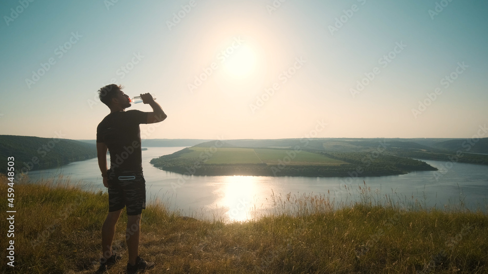 Fototapeta premium The man drinking water on a beautiful river background