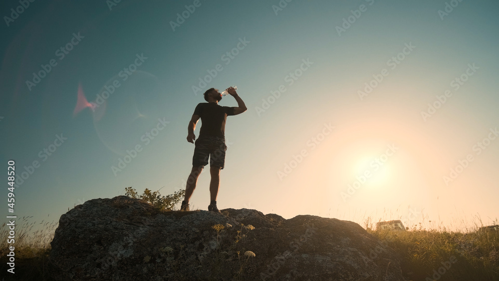 The man drinking water on a mountain top