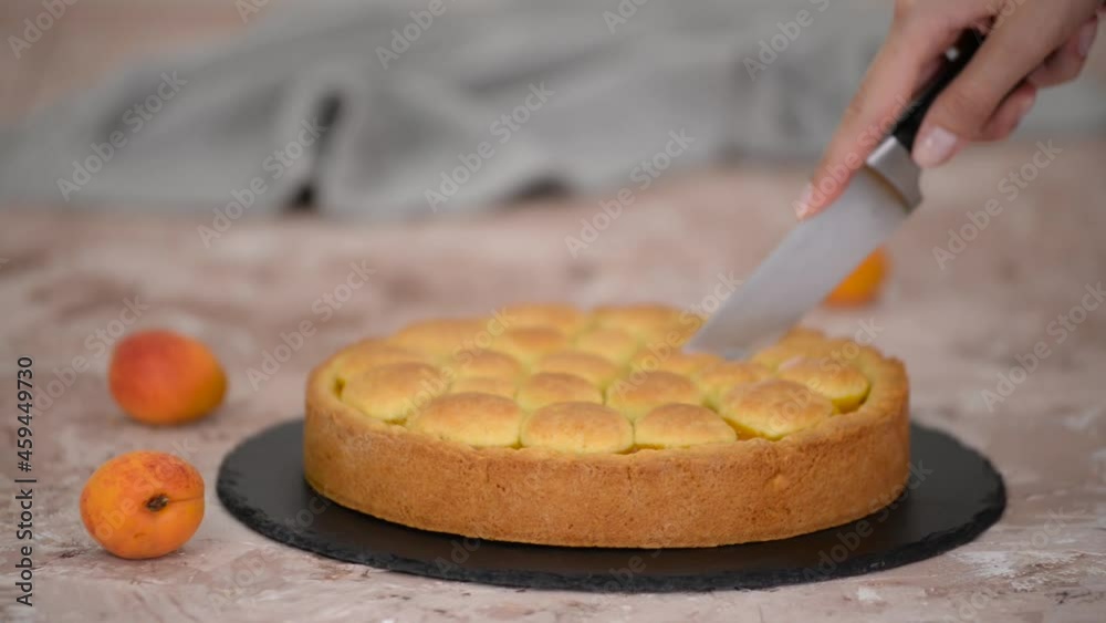 Woman cutting a apricot shortcrust pie. Fresh apricot pie. Woman cutting a apricot shortcrust pie. Fresh apricot pie.