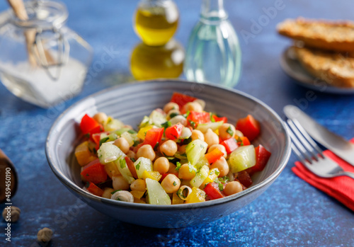 Homemade chickpea salad. Homemade healthy vegan salad  with chickpea   tomato  cucumber  paprika served in a bowl. Healthy meal  on a dinner table.